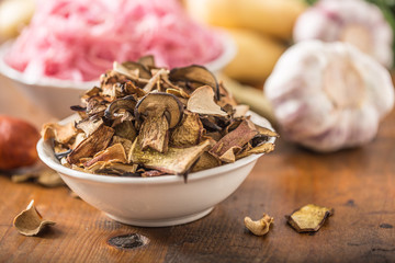 Dried mushrooms sour cabbage garlic and potatoes on wooden table