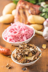 Dried mushrooms sour cabbage garlic and potatoes on wooden table