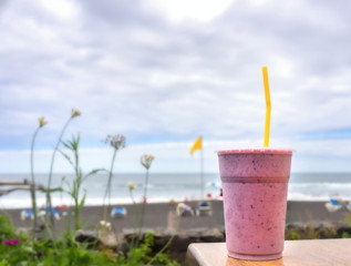 a big vessel with strawberry milkshake is on the right front in the picture on a table