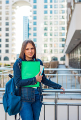 Back to school student teenager girl holding books and note books wearing backpack. Outdoor portrait of young teenager brunette girl with long hair. girl on city