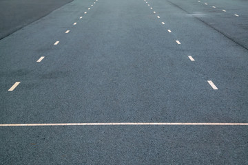 White dotted lines marking on asphalt natural background. Roadway line.