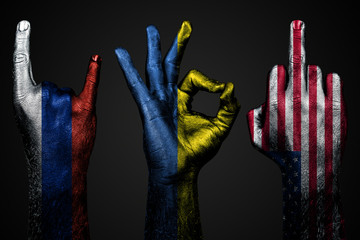 a set of three hands with a painted flag of Ukraine, Russia and USA show middle finger, goat and...