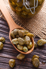 pickled capers on a wooden rustic background