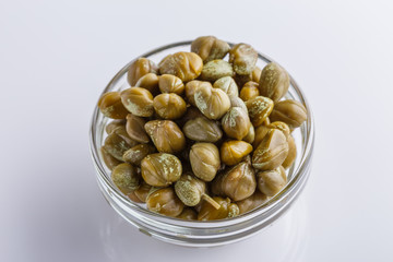Pickled capers on a white acrylic background