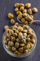 pickled capers on a dark stone background