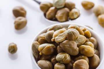 Pickled capers on a white acrylic background