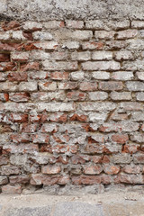 Old destroyed red brick wall as background vertical view closeup