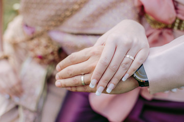 The Asian Couple holding hands together at the wedding day.