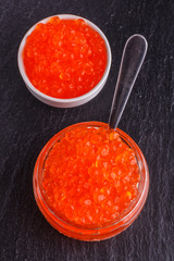red caviar in a bowl on a dark stone background