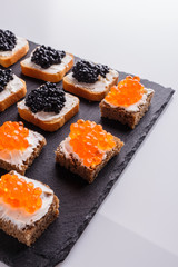 Snack with red and black caviar on a stone plate