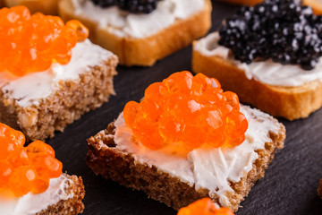 Snack with red and black caviar on a stone plate