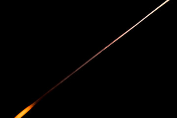 Narrow beam of light on the blade of a steel knife on a black abstract background