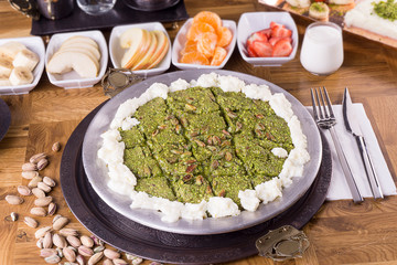 turkish dessert kunefe on kaymak, cream slide with pistachio powder
