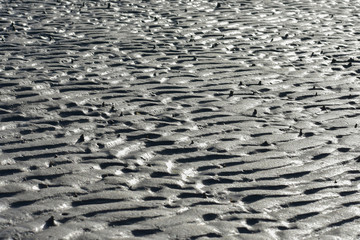 Natural pattern of ripples in the sand at low tide.