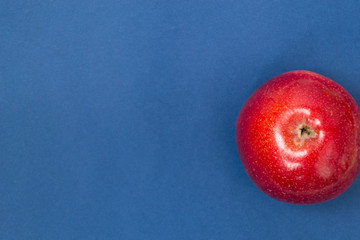 Red apple isolated on blue background.