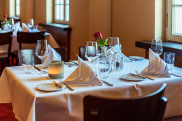 A restaurant. Served tables. Glasses. 