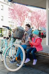 two girls on a bench eating icecream with a bike