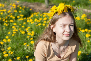 young beautiful girl alone with nature among beautiful yellow dandelions