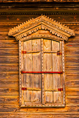 Wooden window with closed shatters made of weathered wood