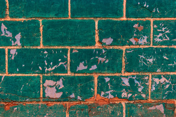 Green brickwall covered with an obsolete stucco