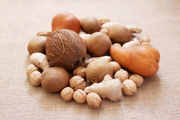 Coconut, walnut, kiwi fruit, brown pear, ginger. Burlap background.