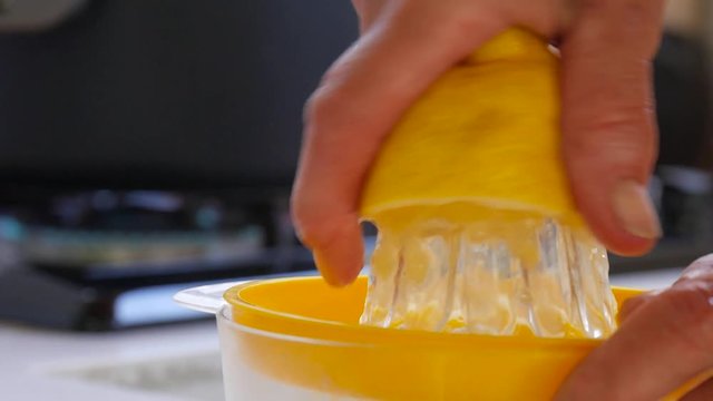 Slow motion juicing a lemon using a plastic citrus juicer