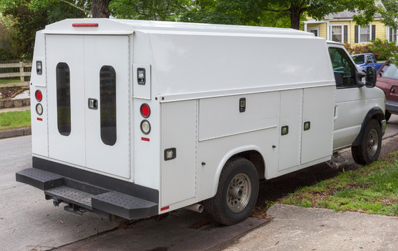 Rear And Side View Of Utility Service Truck Parked On Neighborhood Residential Street.