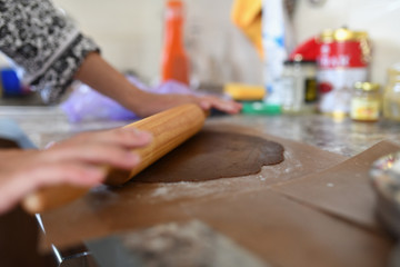 Mom rolls the dough. chocolate dough. Hands work with cake dough recipe preparation. Women's hands, Women's hands roll out the dough. Mom rolls dough on a kitchen board with a rolling pin