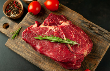 raw beef steak with herbs and spices on a stone background