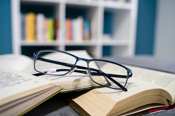 Reading glasses and stack of books reading and learning concept at home school study