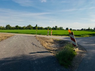 Outdoor sunny view at reconstruction site, repairing a bumpy and hole on asphalt road, is enclosed...
