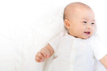 Asian baby happy in the room.Asian baby girl lying down on bed .