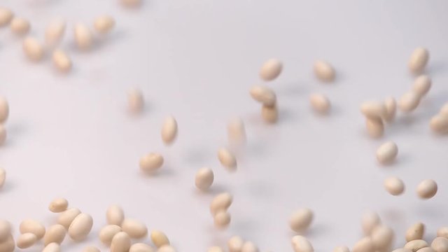 white small bean on white background falling from top and filling up frame. slow motion 96fps