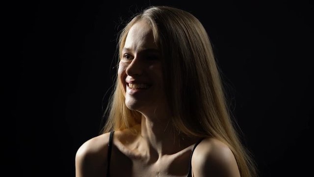 Cheerful woman laughing isolated on dark background, positive thinking, emotions