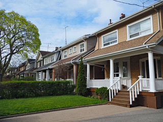 row of small detached houses with full width porch
