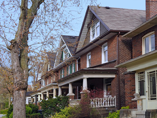 row of old urban houses with gables and large porches