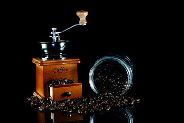 Obraz na płótnie Canvas Coffee beans and vintage wooden coffee grinder on black background.