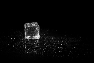 ice cubes reflection on black table background.