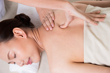Obraz na płótnie Canvas Body Massage on specific naked back of Asian woman by pressing fingers on pain or stress muscle point to release relax. Therapist Spa body massage woman hands treatment on customer, isolated on white