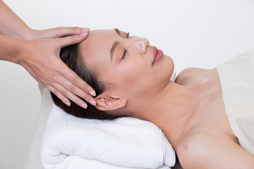 Obraz na płótnie Canvas Ayurvedic Head Massage Therapy on facial forehead Master Chakra Point of Asian woman, Therapist Spa body woman hands treatment on customer to increase circulation release tension stress, isolated