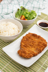 Close up rice bowl and deep-fried pork cutlet decorated with salad