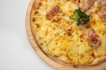 Close up melting cheesy pieces of home made pizza on wooden plate