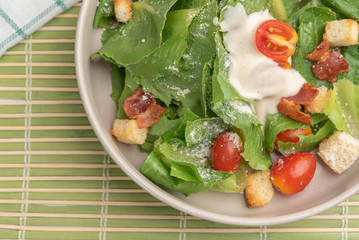 Close up healthy salad with various fresh vegetables, tomatoes, green oak lettuce