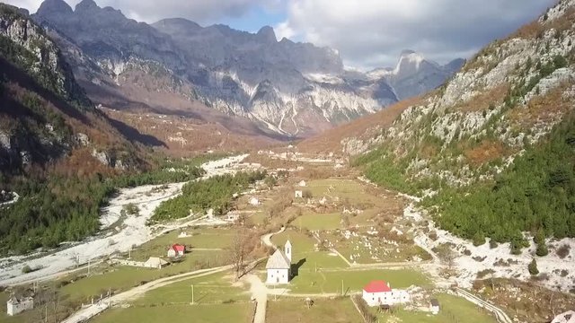 Looking down Theth valley with Theth church with the Albania alps in the background at sunrise
