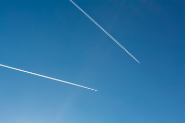Two planes with traces on a blue sky background.