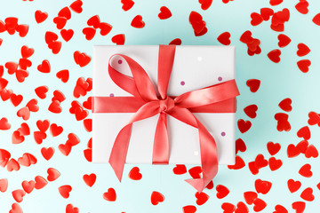 Gift box with ribbon on blue background close-up, top view