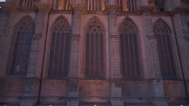 Gothic windows of St. Barbara's Cathedral in Kutna Hora, Czech Republic, tilting up evening shot with lights
