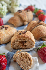 Homemade fresh golden croissants with strawberries and white lilac 
