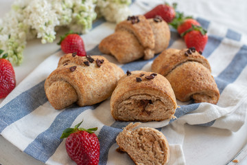 Homemade fresh golden croissants with strawberries and white lilac 