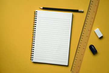 close up top view of school stationery on yellow background for education concept